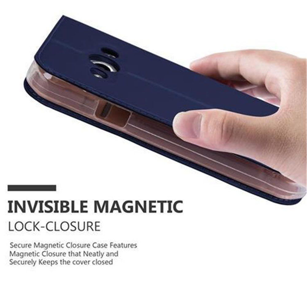 Una mano tiene una custodia blu scuro con chiusura magnetica invisibile.