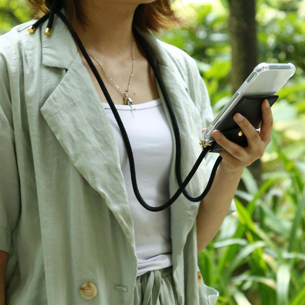 Una donna tiene un telefono con un laccio nero al collo, all'aperto.
