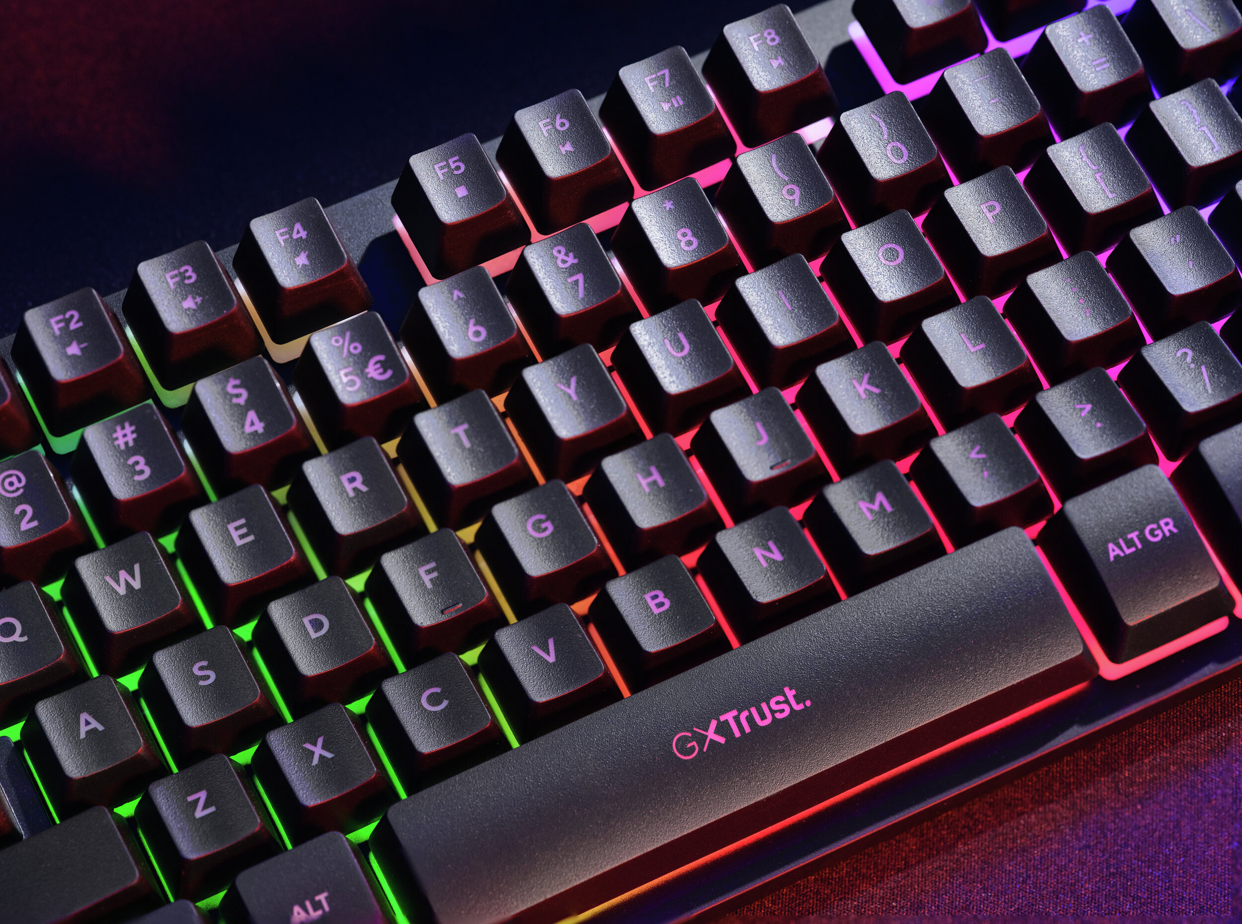 Un primer plano de un teclado negro con iluminación RGB que ilumina las teclas.