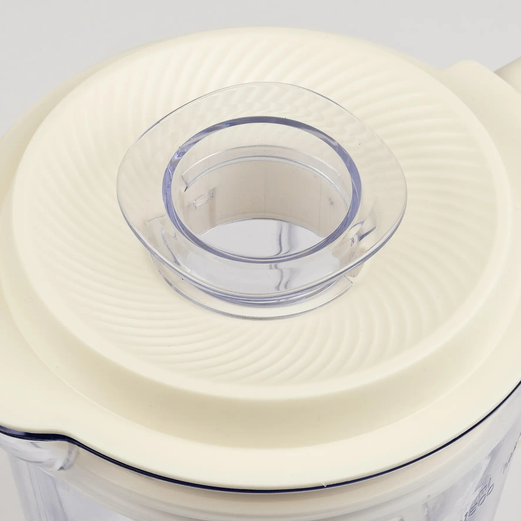 Coperchio beige con inserto trasparente e scanalature.