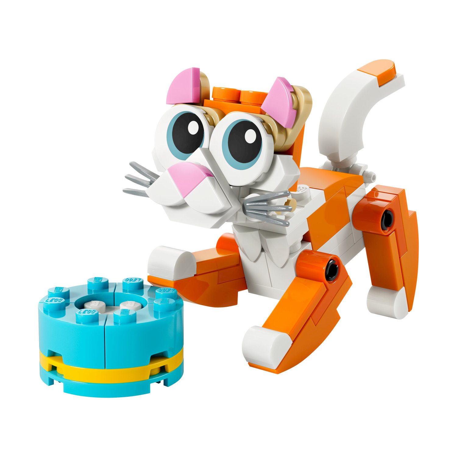 Pomarańczowo-biały kotek Lego z dużymi niebieskimi oczami i różowymi uszami siedzi obok niebieskiego cylindra Lego.
