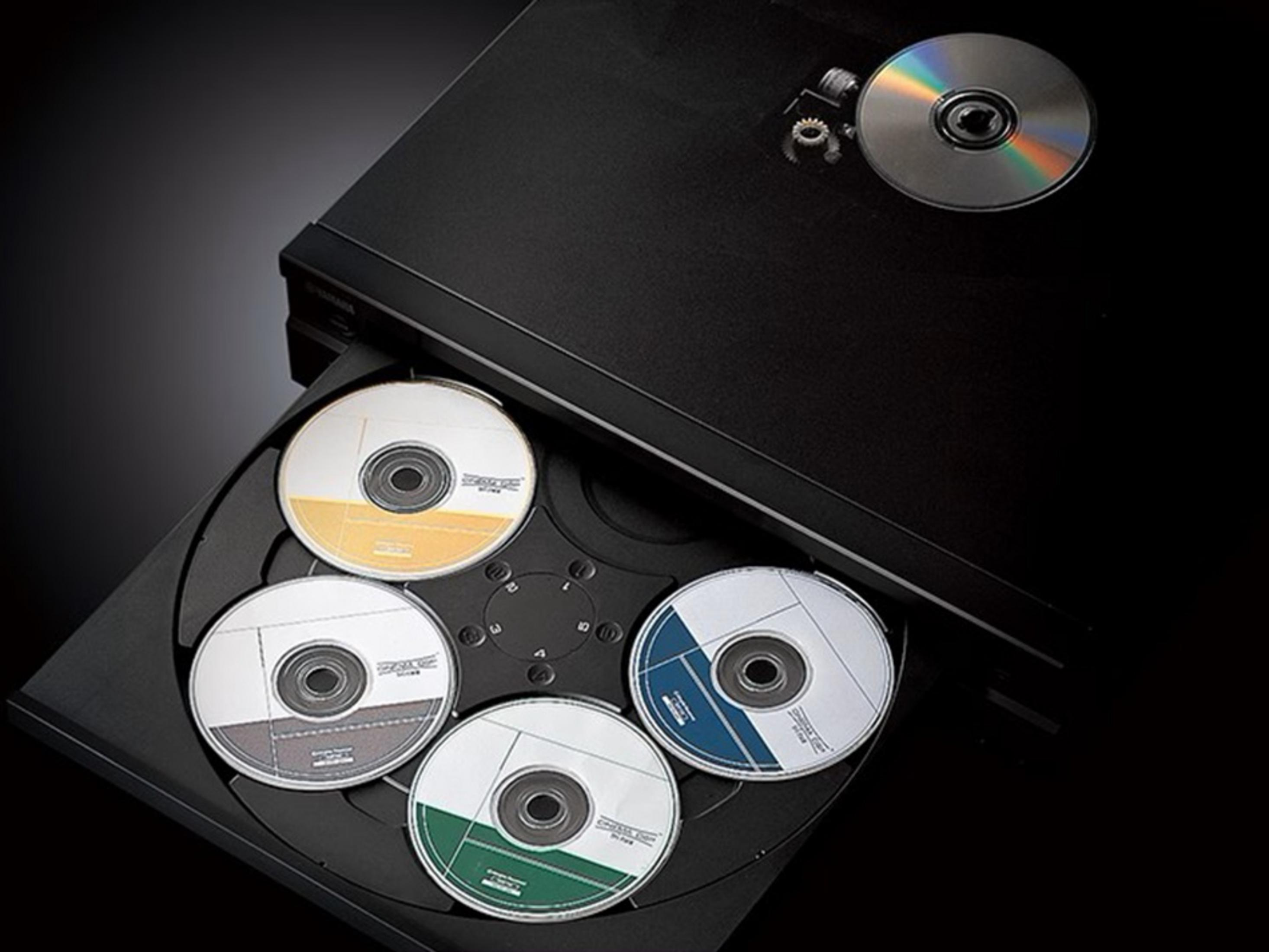 Lettore CD nero con vassoio aperto contenente 4 CD, un CD sopra.