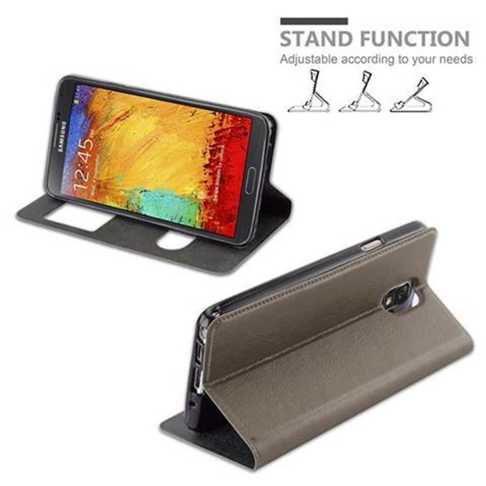 Un teléfono inteligente en una funda marrón que sirve de soporte.