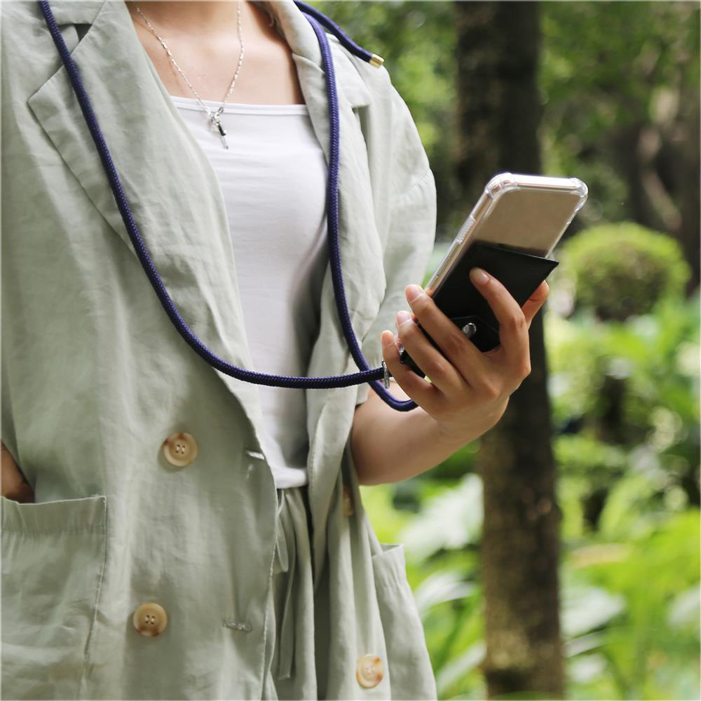 Donna con smartphone e cordino, all'aperto con alberi sullo sfondo.