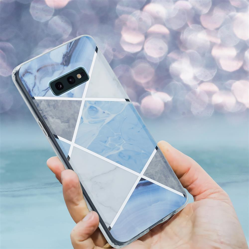 Mano che tiene un telefono con cover marmorizzata e geometrica.