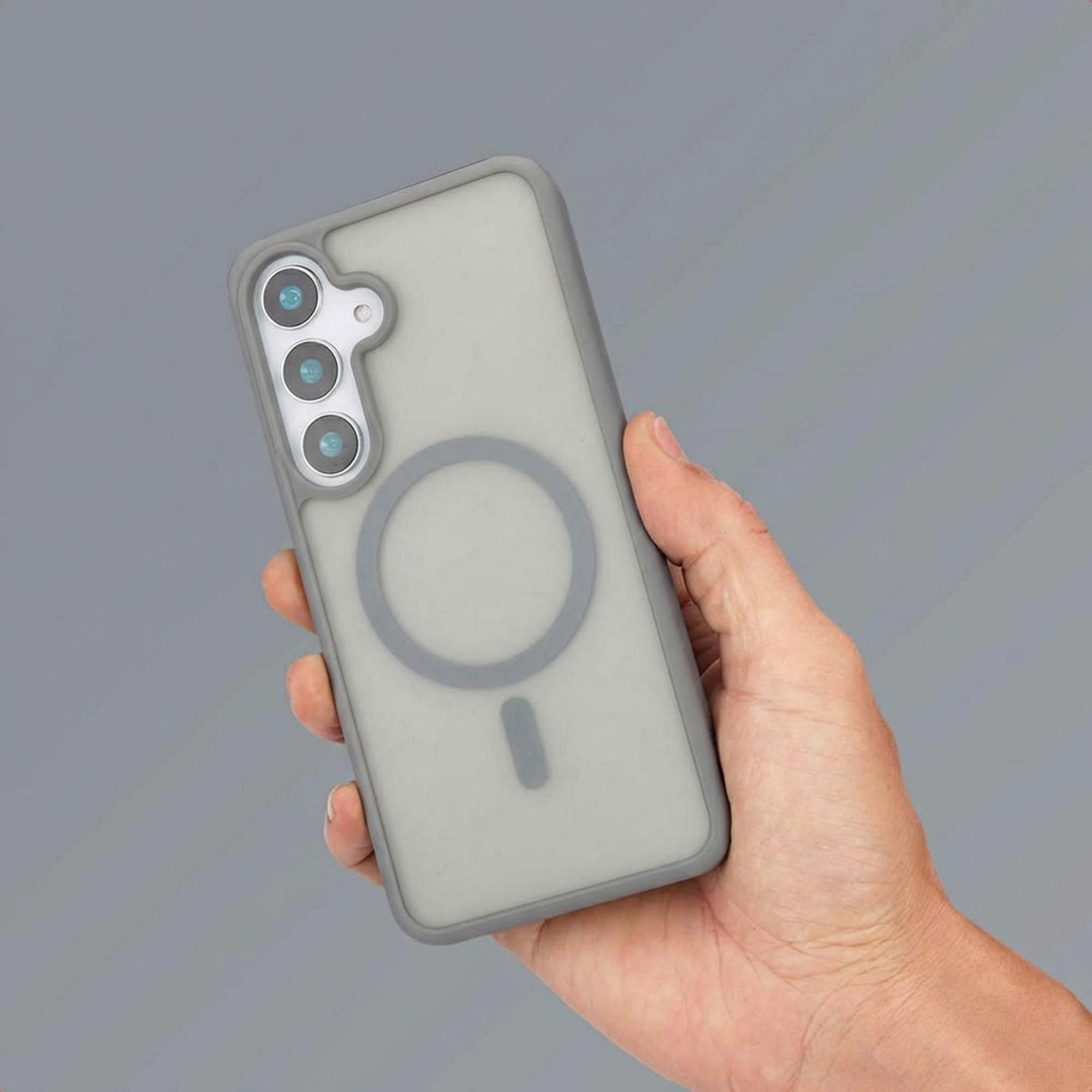 Een hand houdt een doorschijnende grijze telefoonhoes vast met drie cameralenzen.