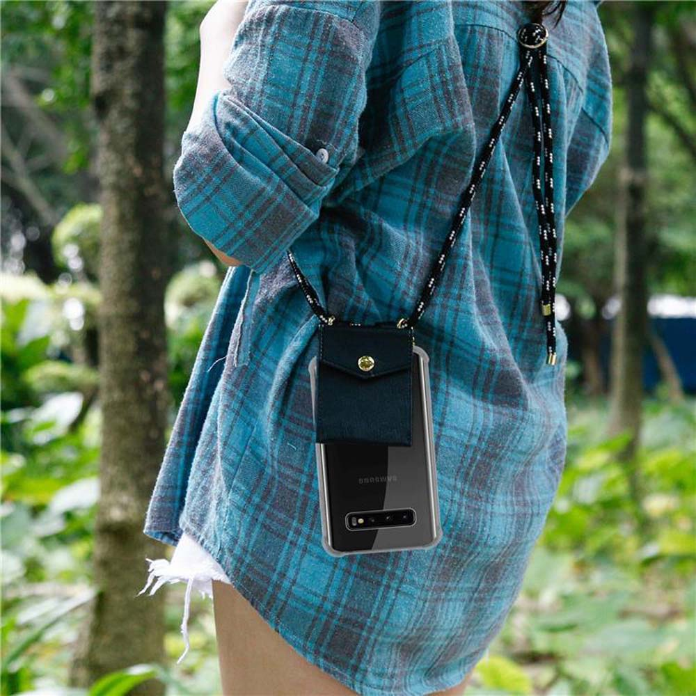 Persona con camicia a quadri blu, tiene il telefono con tracolla all'aperto.