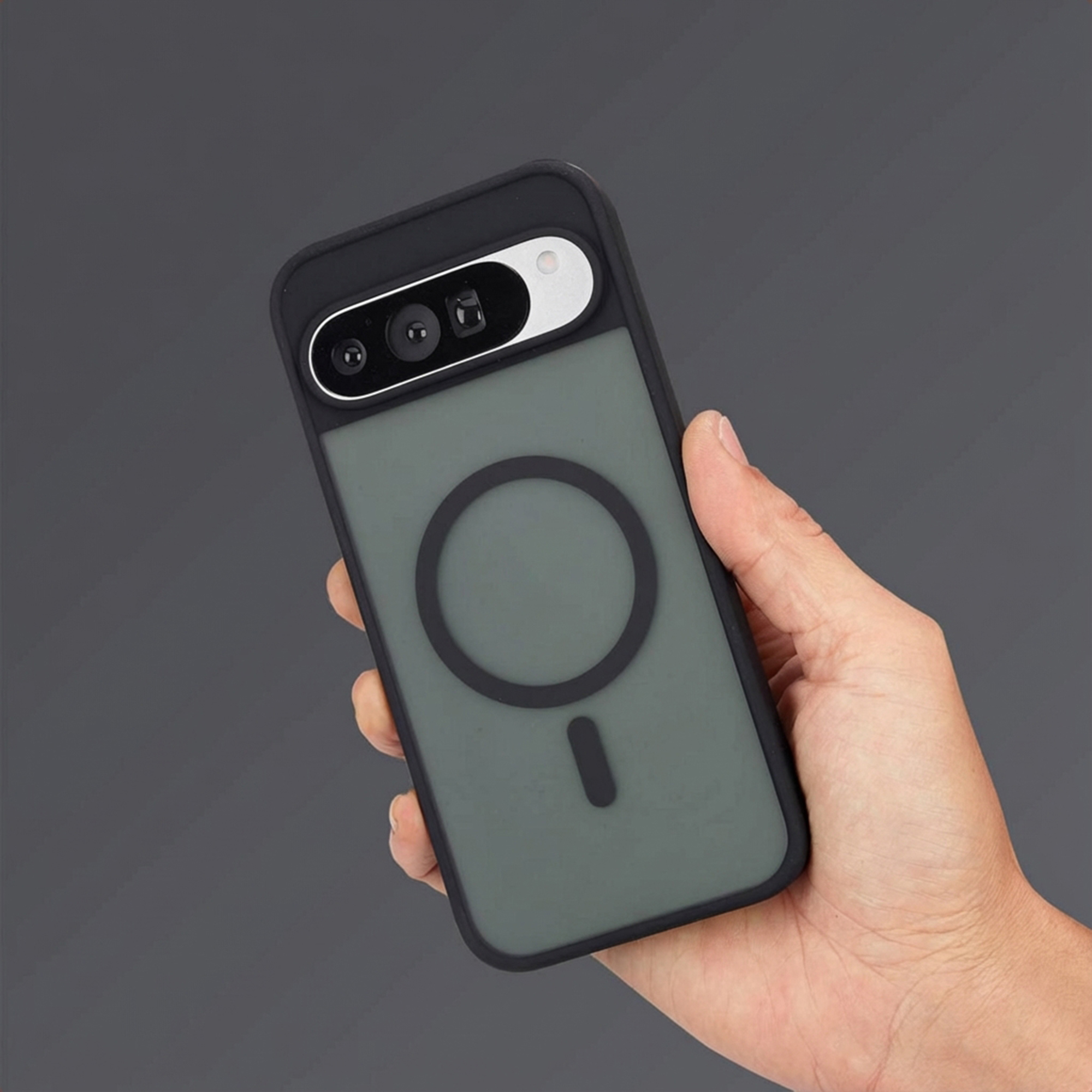 Une main tient un téléphone noir avec une unité caméra et un cercle au dos.