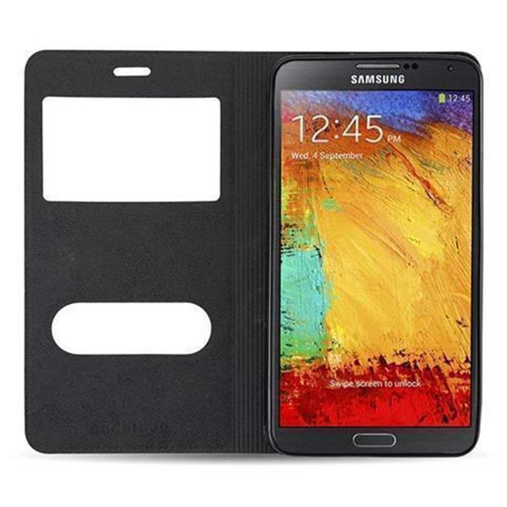 Un teléfono inteligente negro con una funda abierta, mostrando su pantalla de bloqueo.
