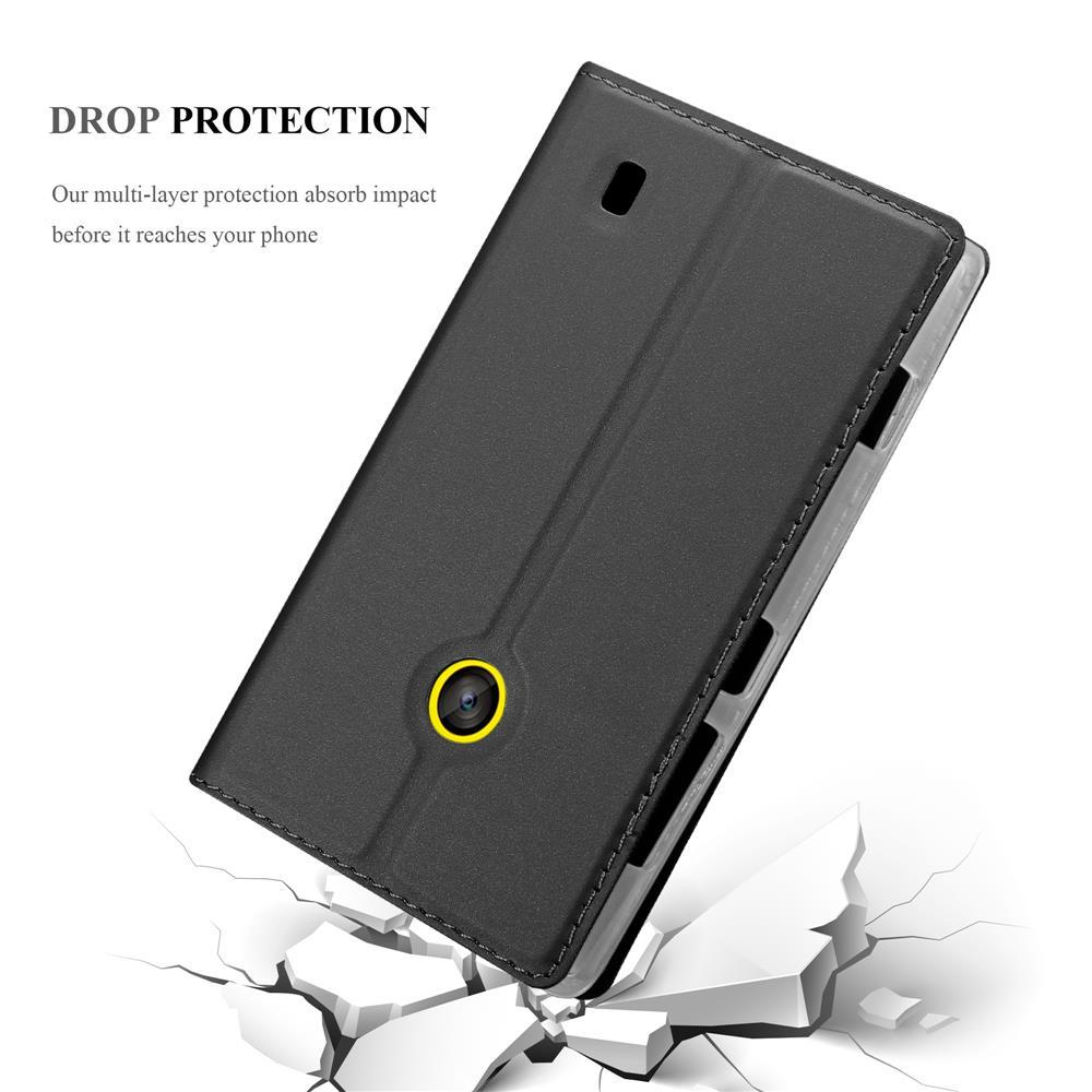 Funda negra para teléfono con anillo de cámara amarillo sobre suelo agrietado.