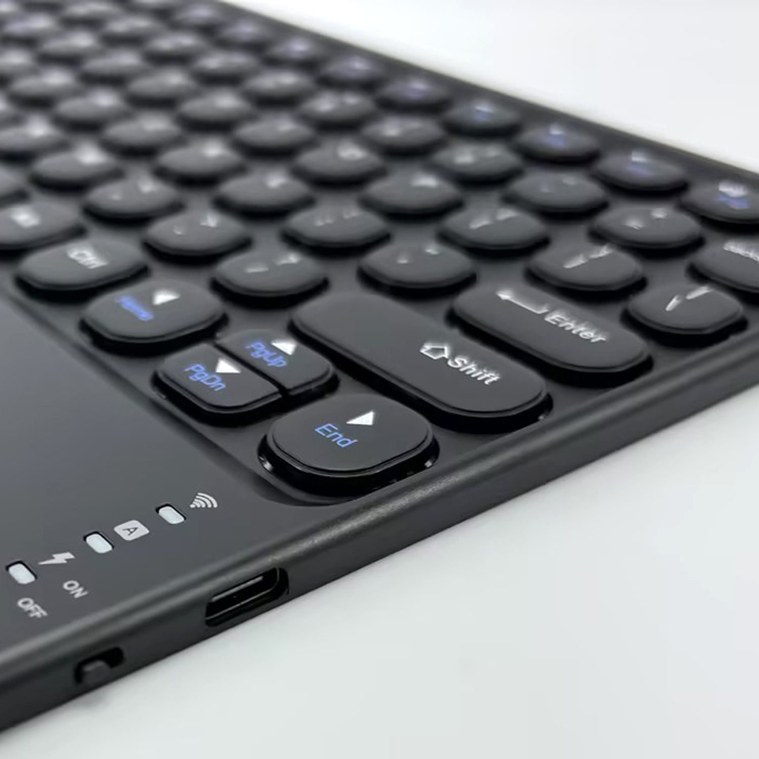 A black keyboard detail with round keys and a charging port.
