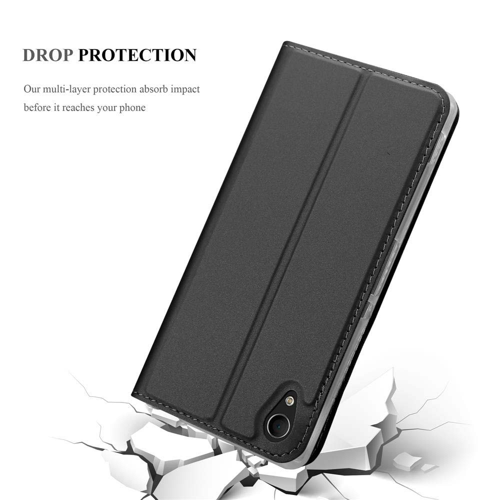 Funda negra para teléfono cayendo sobre suelo agrietado.