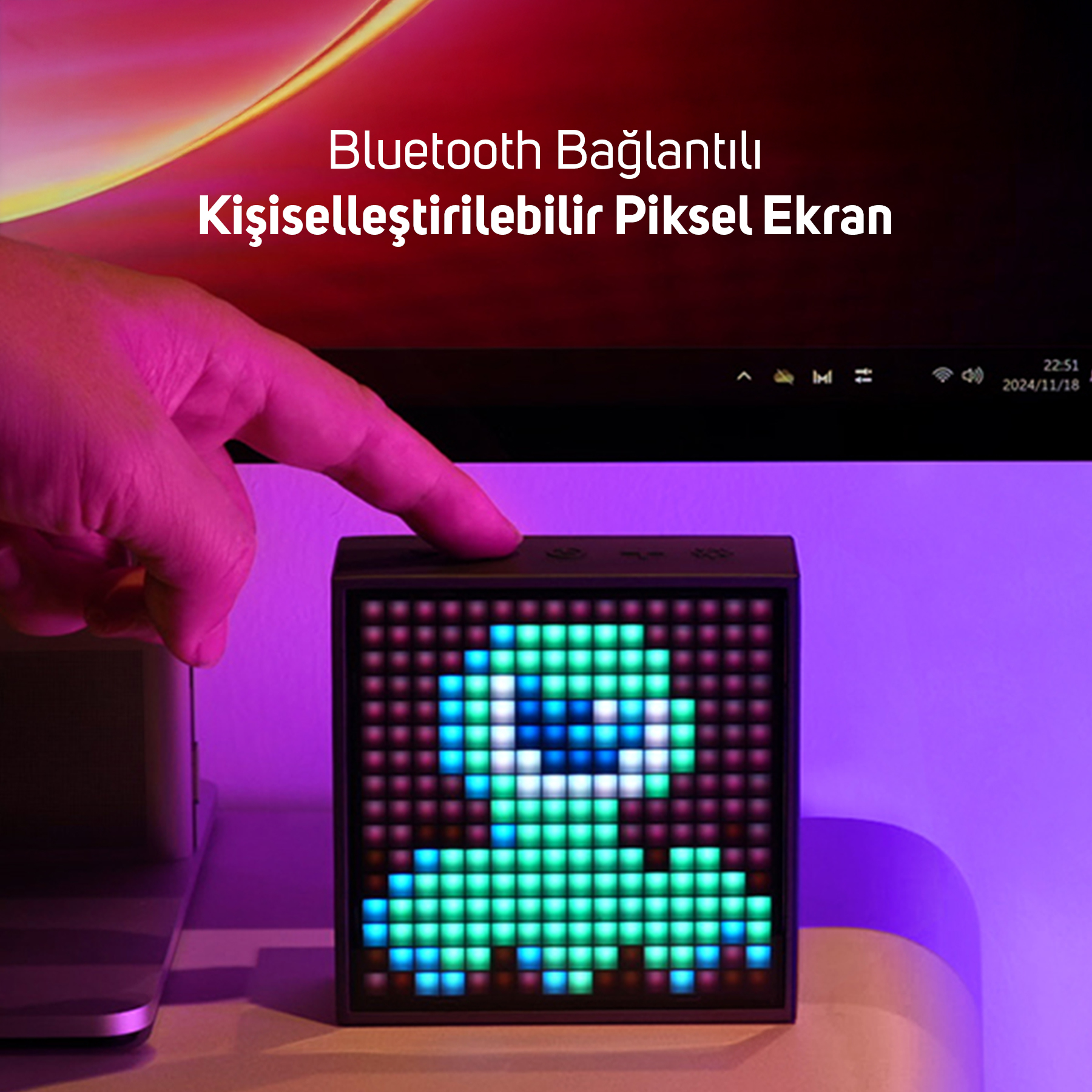 Palec naciska mały wyświetlacz pikselowy pokazujący zielone stworzenie.