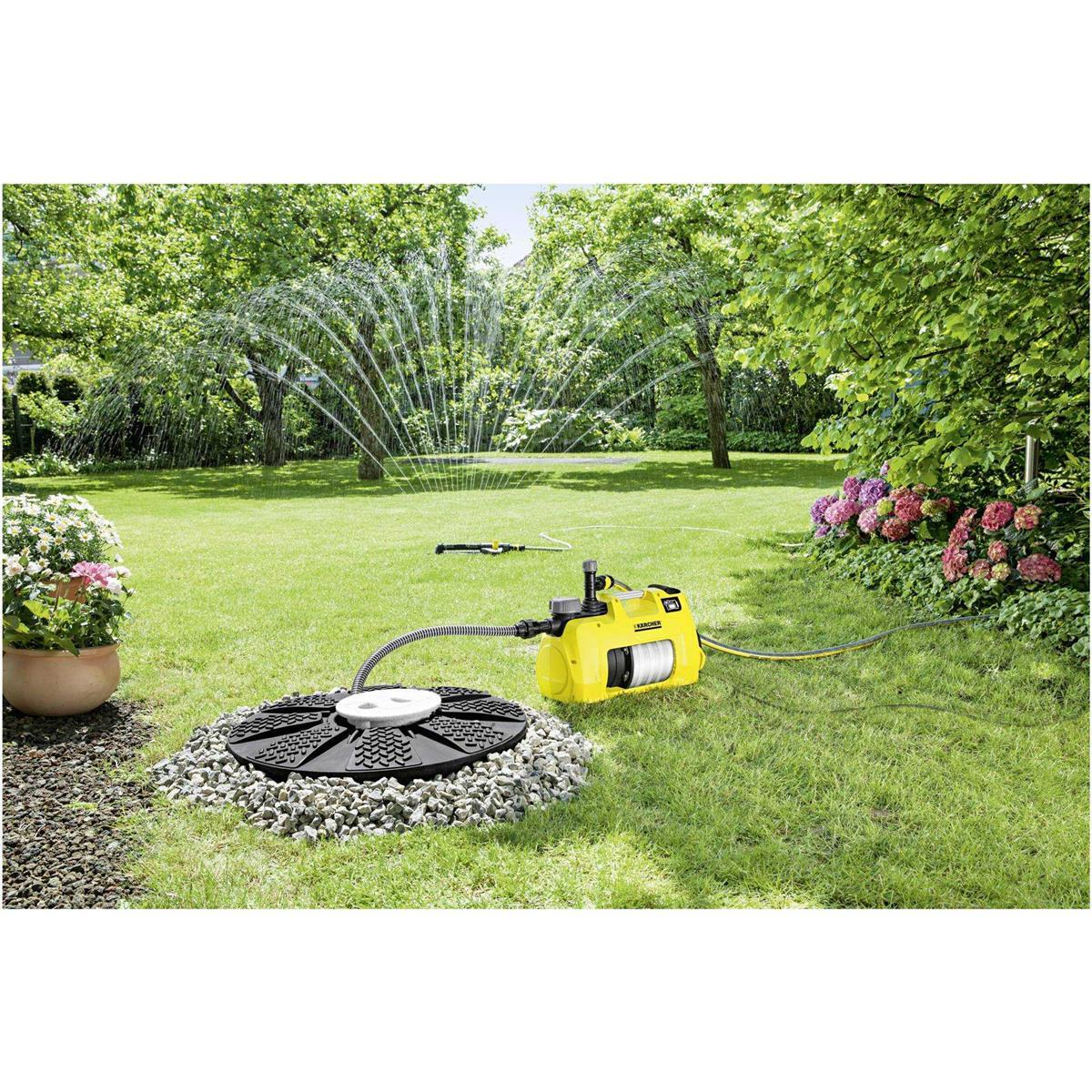 Ein gelber Kärcher-Pumpen-Wasserverteiler mit Bewässerungssystem im Garten.