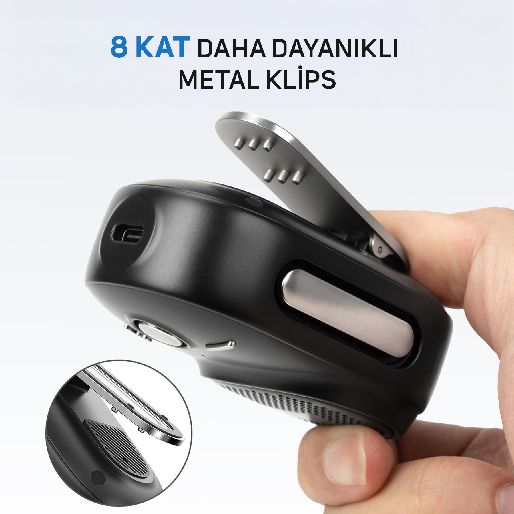 Metal klipsli siyah cihaz, bir el tarafından tutuluyor. Yakın çekim.