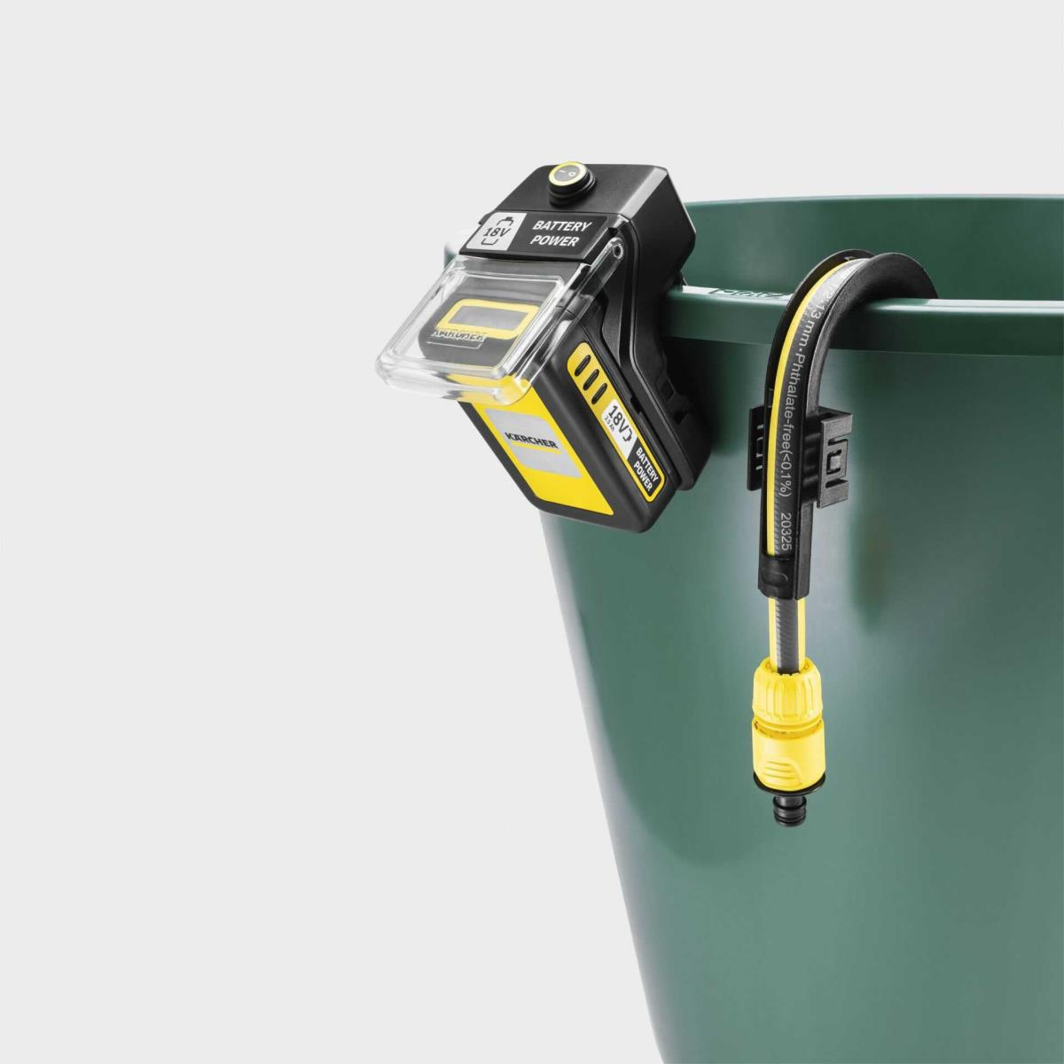 Una batería Karcher de 18V está sujeta a un cubo verde. Una manguera cuelga.