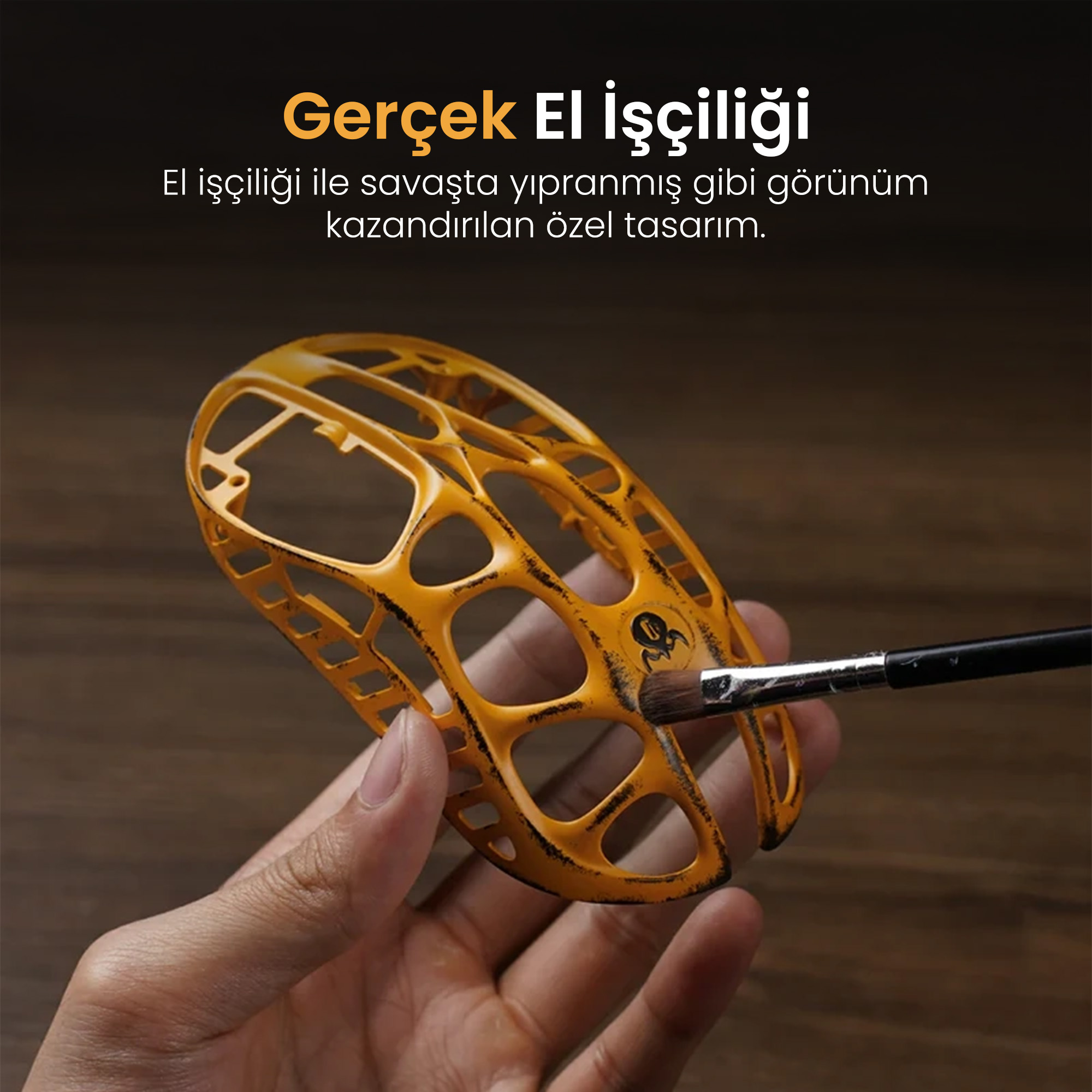 Bir el, üzerine fırça uygulanan sarı, yıpranmış bir nesne tutuyor.