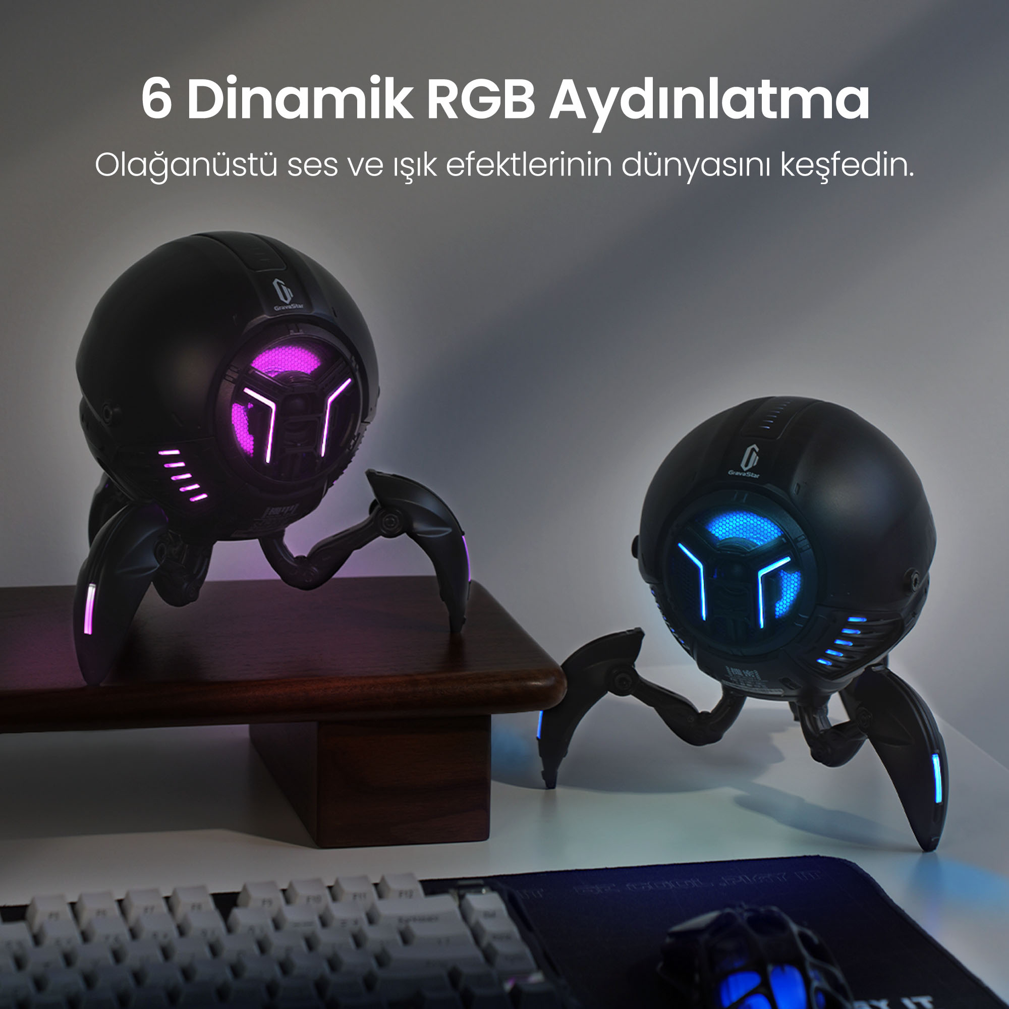 RGB aydınlatmalı iki siyah hoparlör masada duruyor.