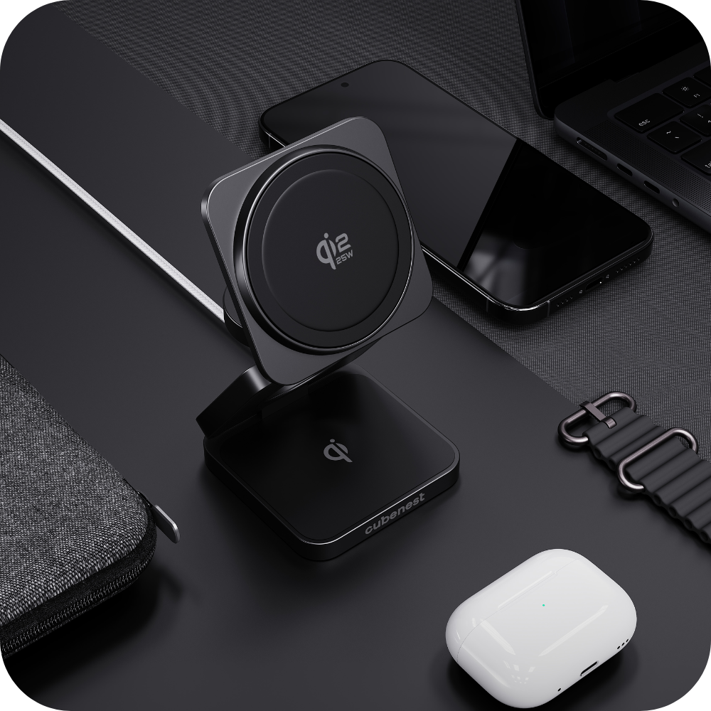 Ein schwarzes Qi-Ladegerät mit einem Smartphone, Laptop und Ohrhörern.