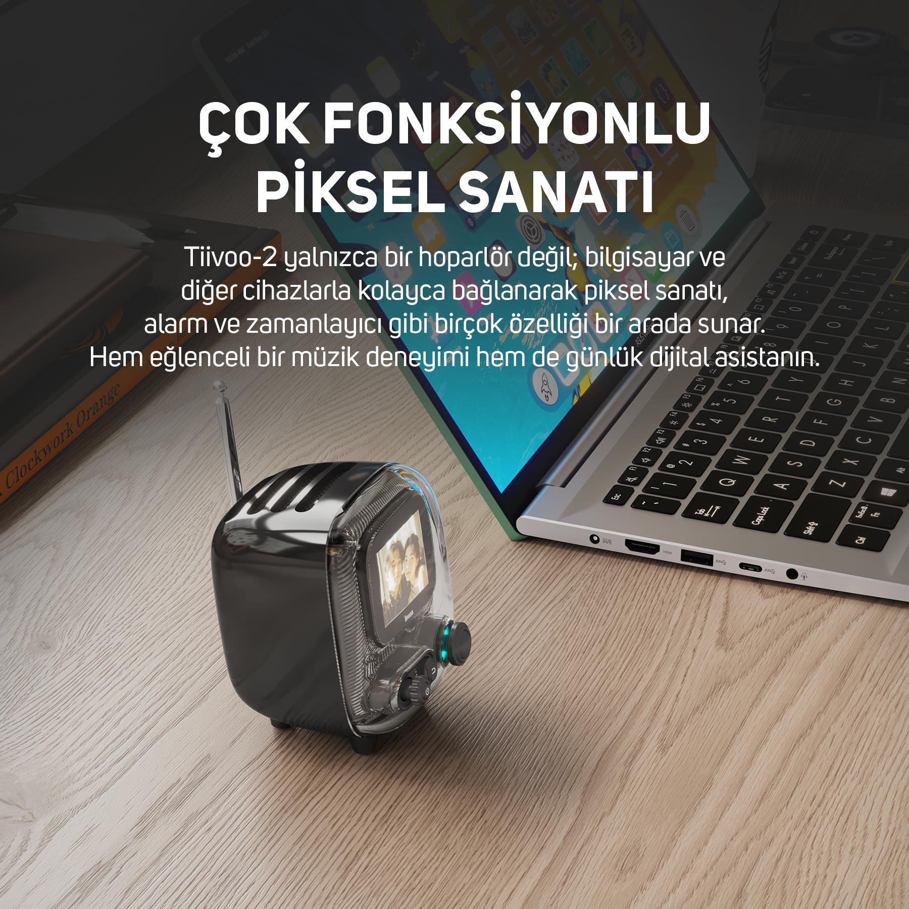 Ekranlı retro radyo, ahşap bir masanın üzerinde açık bir dizüstü bilgisayarın yanında duruyor.