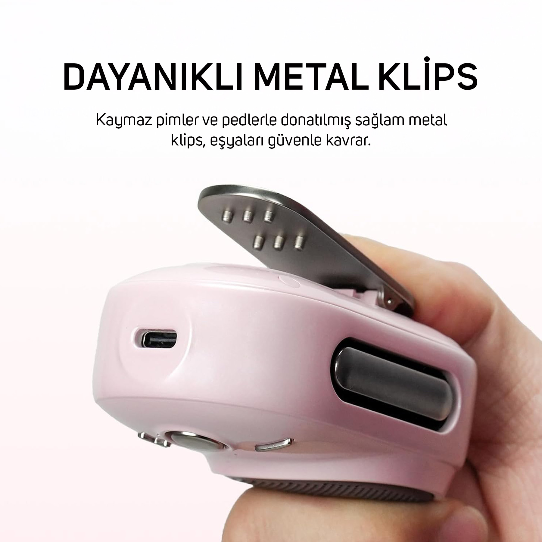 Metal uçlu ve USB-C portlu pembe klips bir el tarafından tutuluyor.