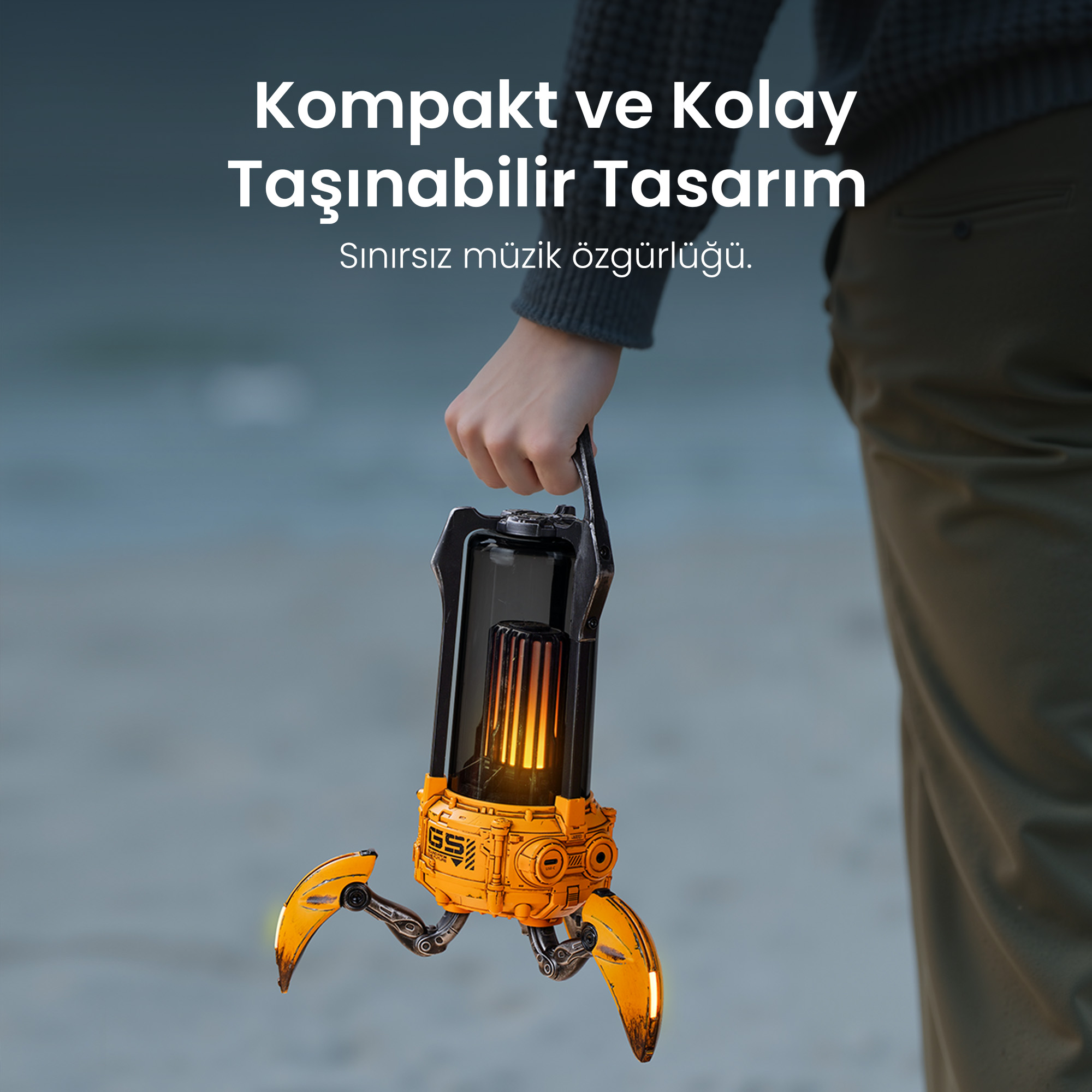 Dłoń trzyma pomarańczowy, futurystyczny głośnik ze świecącymi elementami.