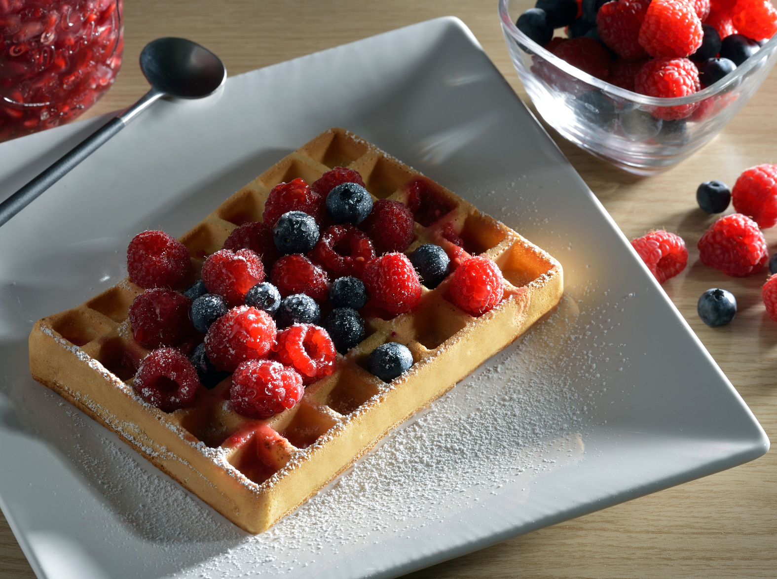 Prostokątny wafel z jagodami i posypany cukrem pudrem.