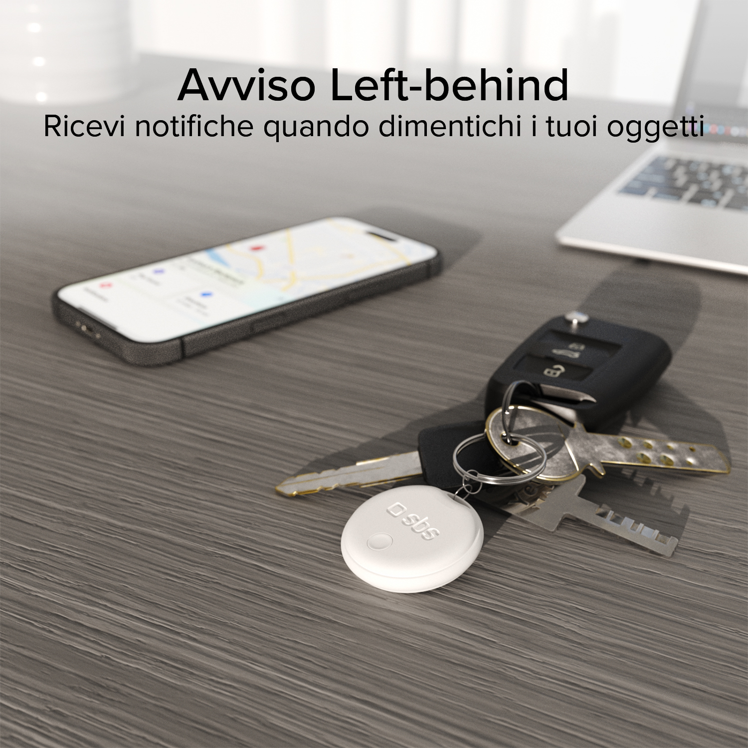 Un localizador blanco cuelga de un llavero junto a un smartphone y un portátil.