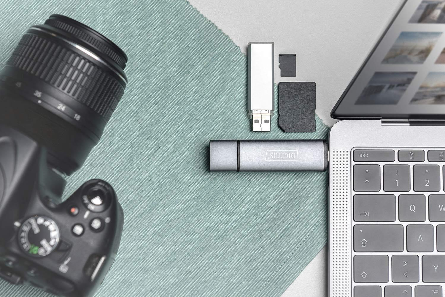 Digitalkamera, Laptop, USB-Sticks und SD-Karte auf Stoff.