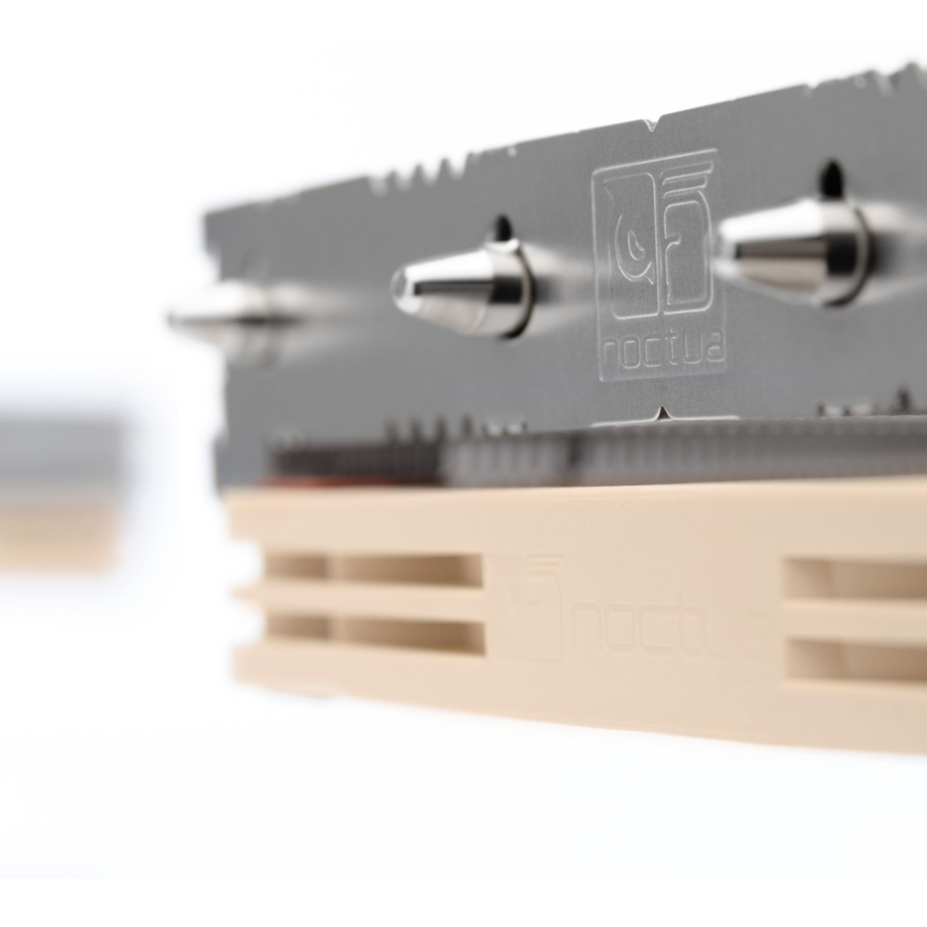 Zbliżenie srebrnego radiatora CPU z piastą wentylatora i logo Noctua.