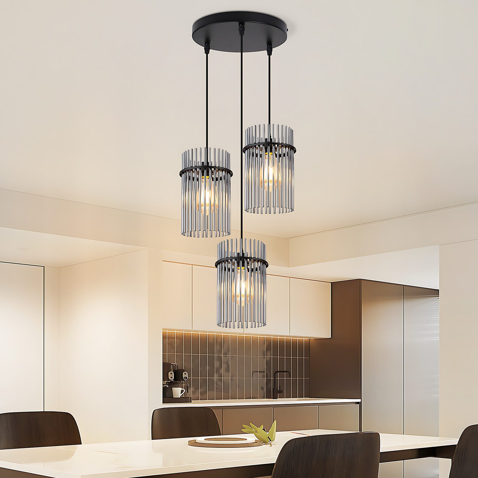 Lampadario con tre paralumi cilindrici in aste di vetro.