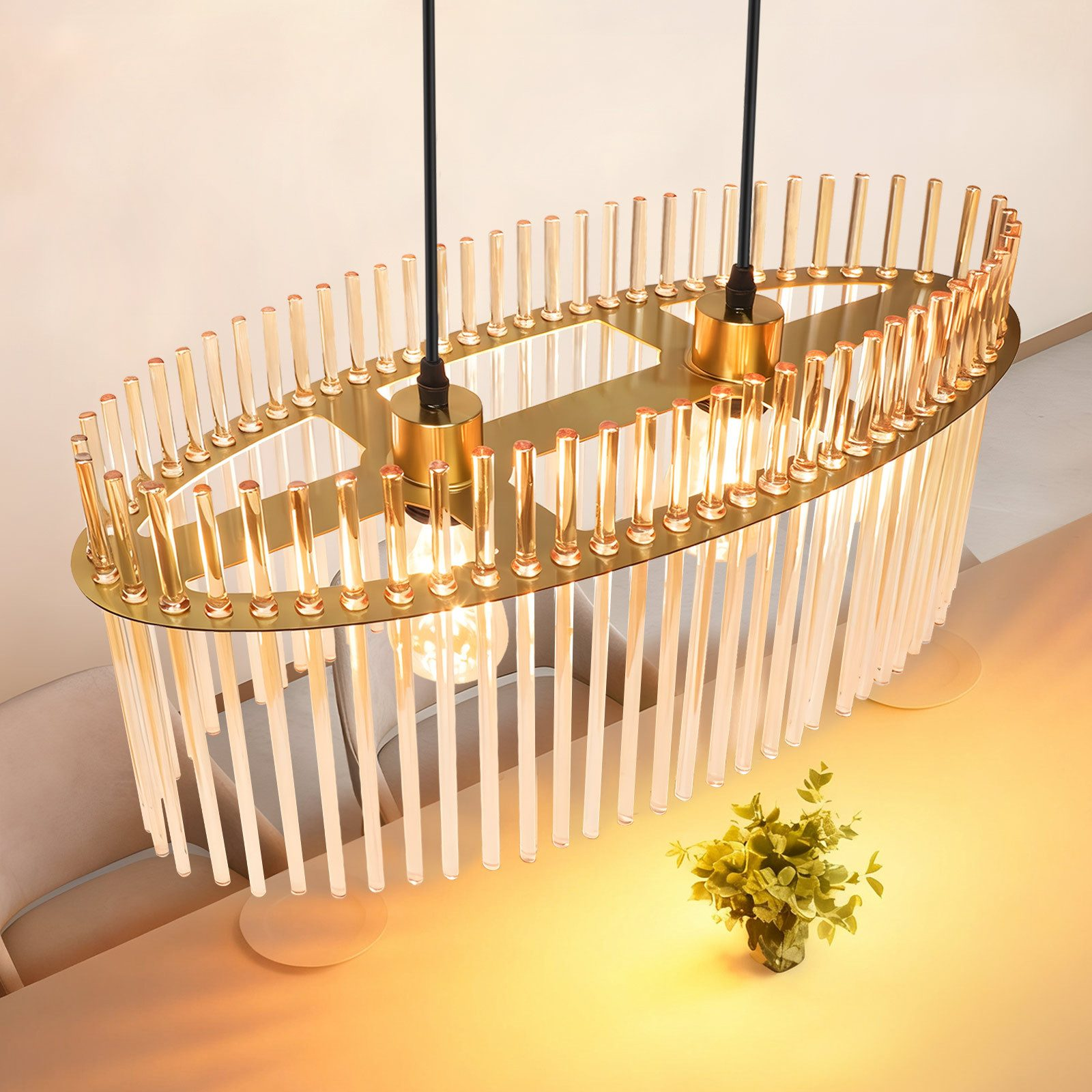 Lampadario ovale dorato con aste di vetro sopra un tavolo.
