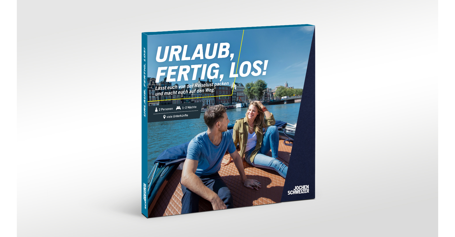 Ein Paar auf einem Boot in einem Kanal mit Gebäuden im Hintergrund.