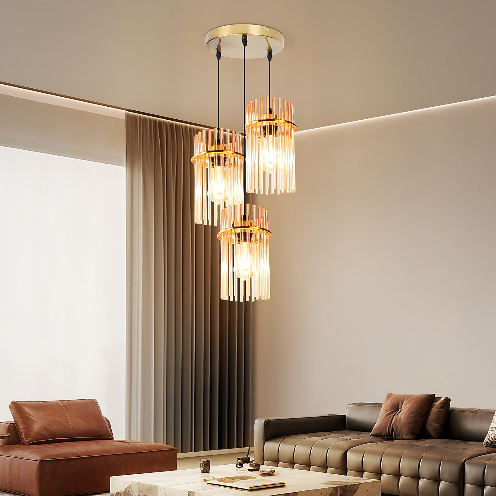 Un lampadario dorato con tre cilindri di vetro appeso sopra un soggiorno.