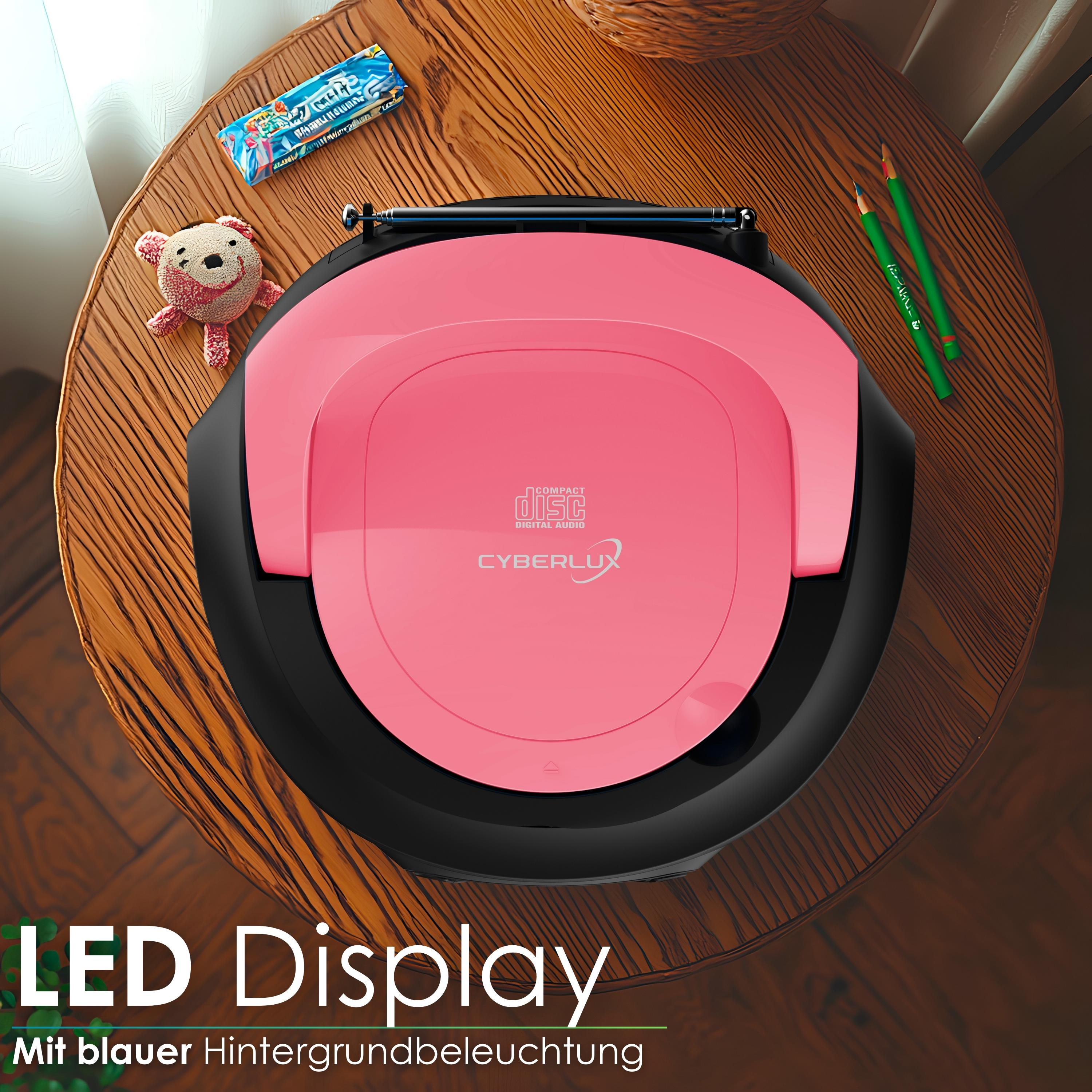 Ein pinker CD-Player mit Teddy, Bonbons und Bleistiften auf einem Holztisch.
