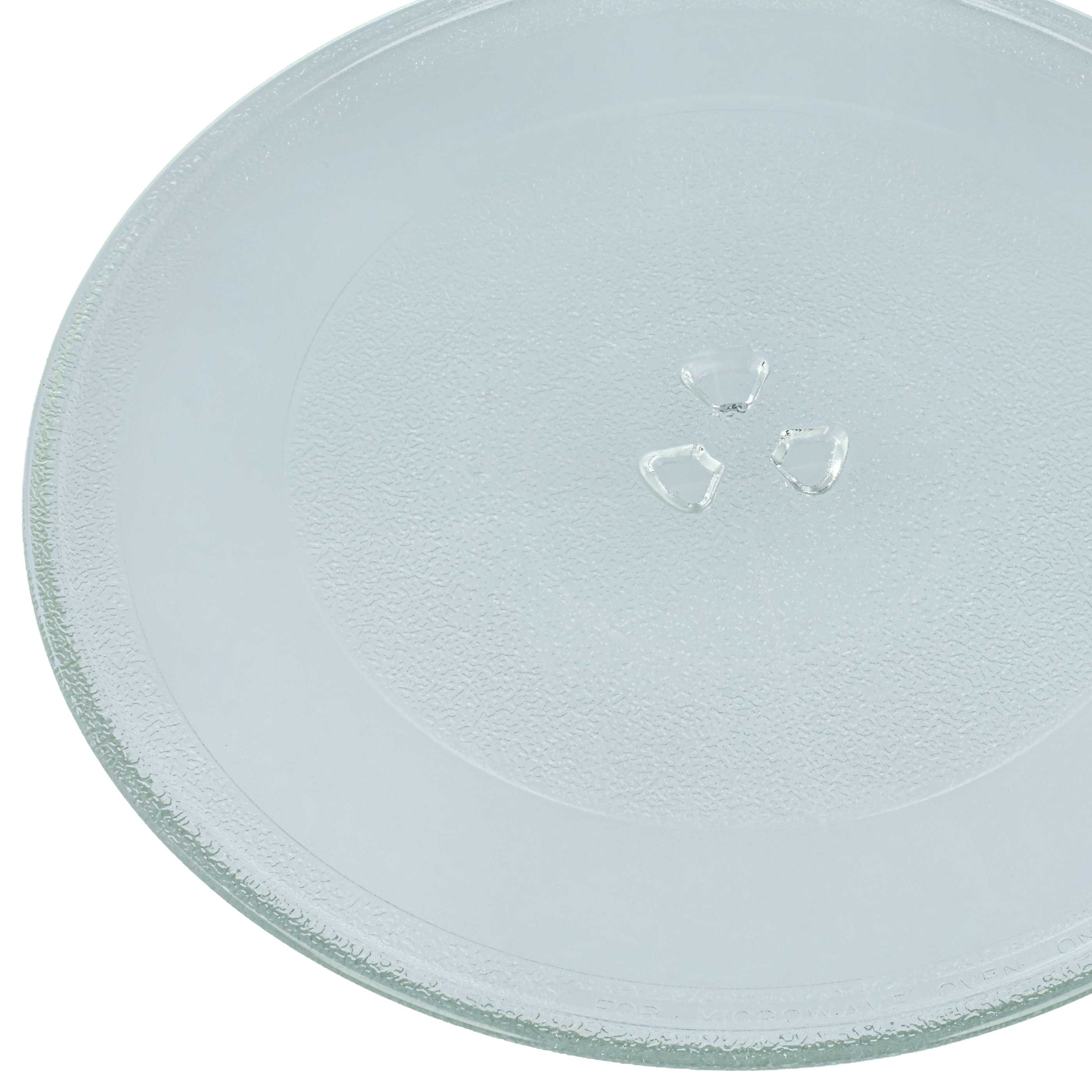 Ein runder Glas-Mikrowellenteller mit einem strukturierten Rand und drei kleinen Glasstücken.