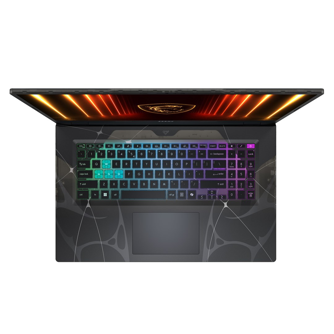 Otwarty laptop z podświetlaną klawiaturą i pomarańczową poświatą na ekranie.