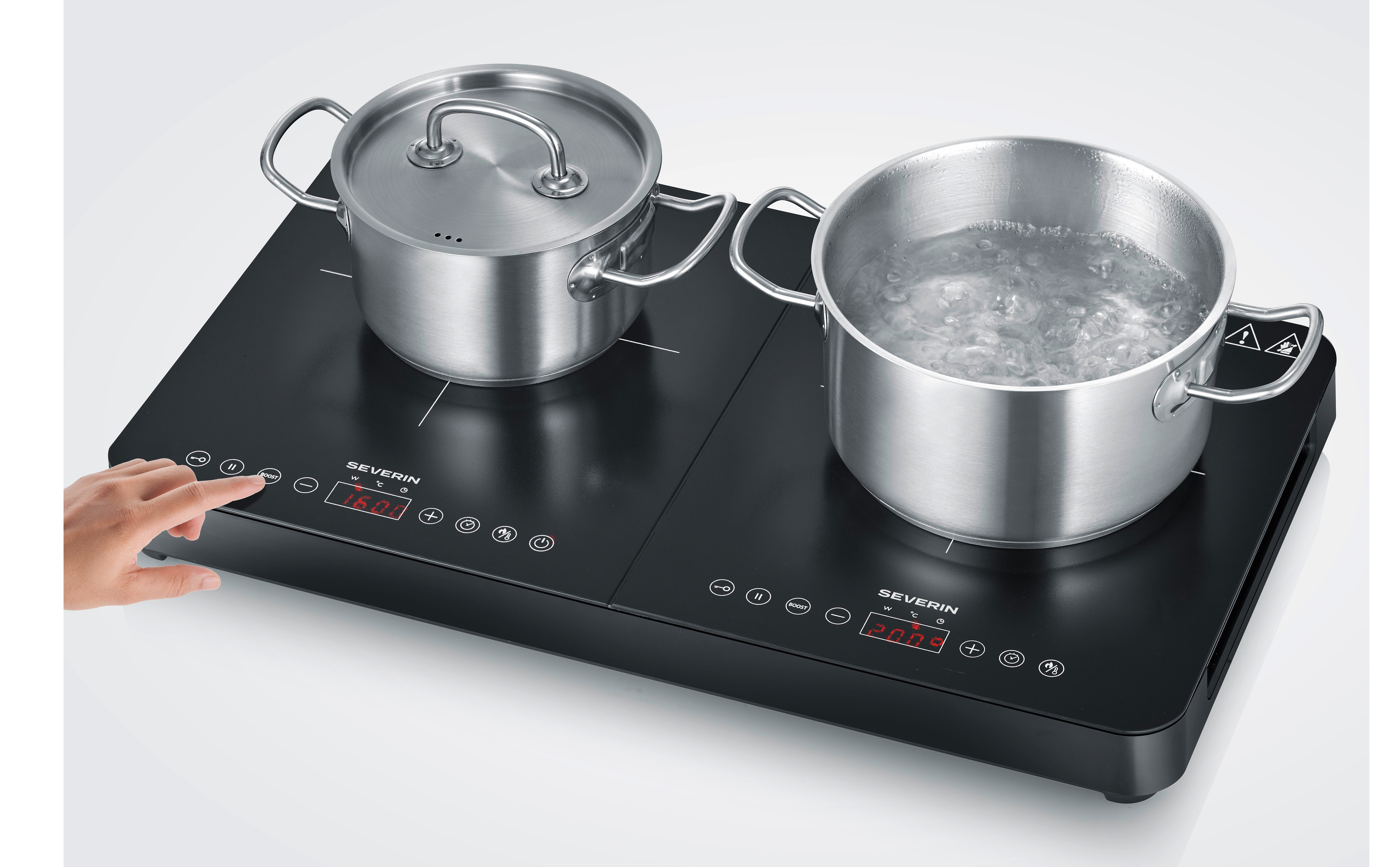 Dłoń obsługuje czarną płytę indukcyjną z dwoma garnkami. Jeden gotuje wodę.