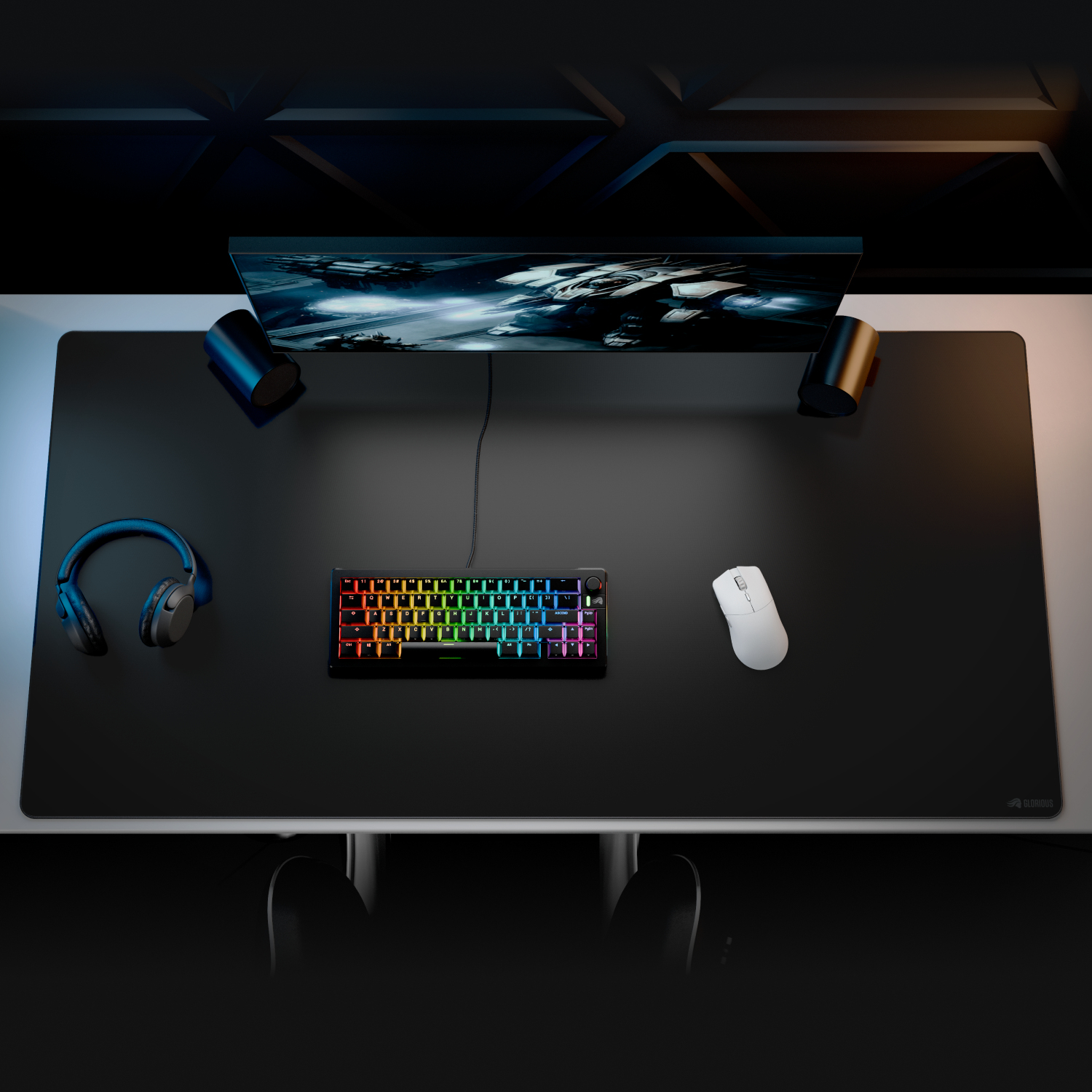 Un escritorio con teclado, ratón, auriculares y monitor mostrando naves espaciales.