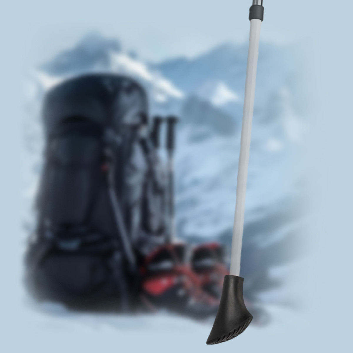 Kijak trekkingowy stoi na zaśnieżonym tle z plecakiem i kijkami.