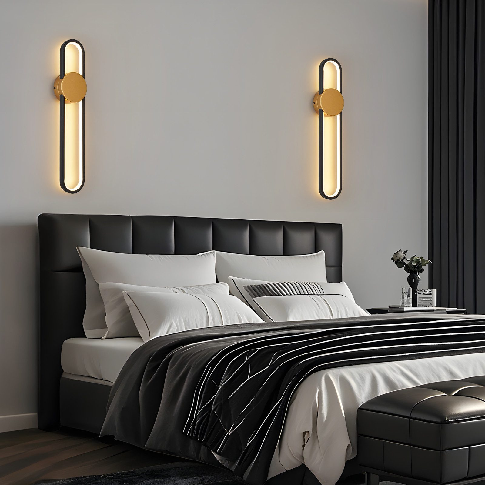 Una camera da letto moderna con letto nero, cuscini bianchi e due applique.