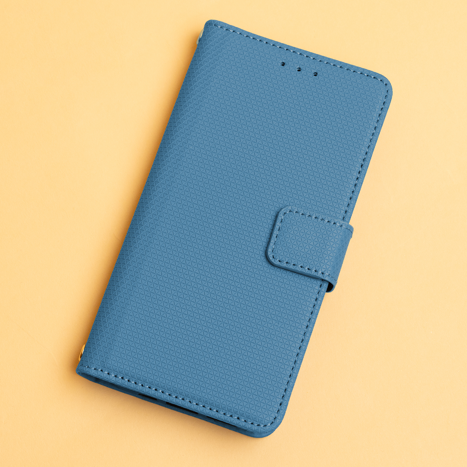 Ein blaues Handycover liegt auf einem gelben Untergrund.