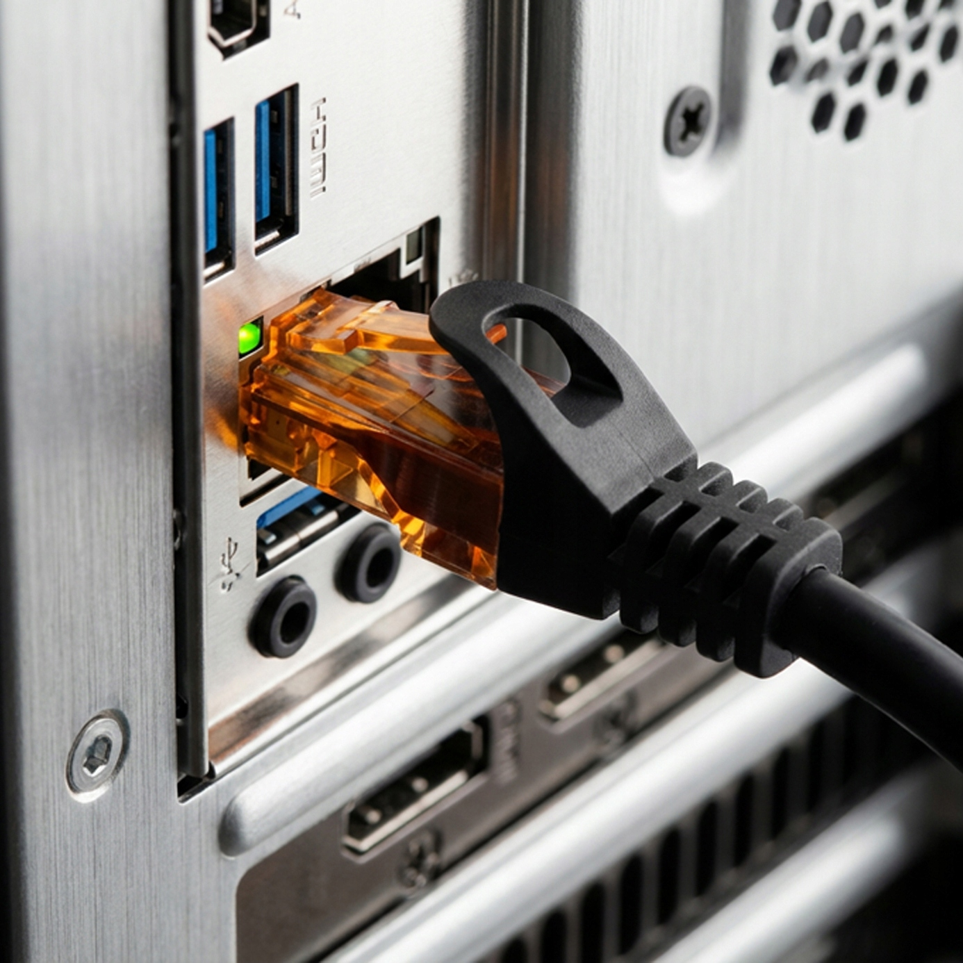 Pomarańczowy kabel sieciowy jest podłączony do portu komputera ze zielonym światłem.