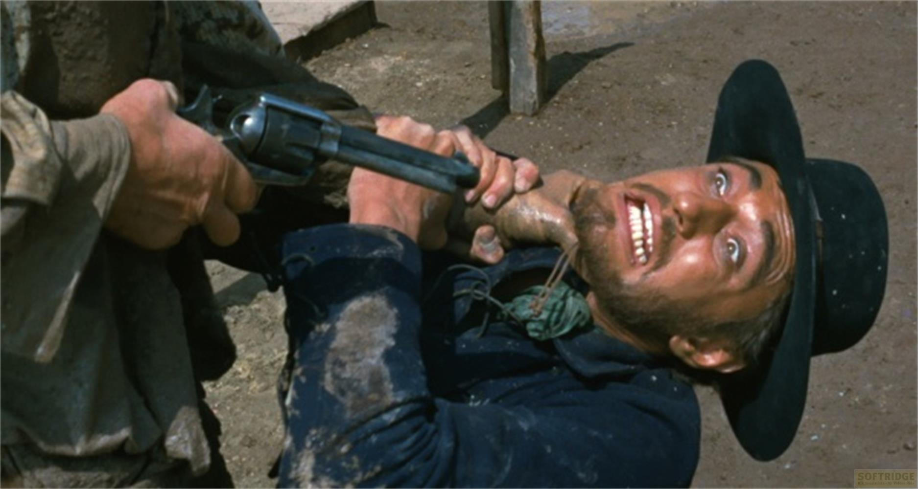 Un uomo con il cappello è minacciato da un revolver puntato al collo.