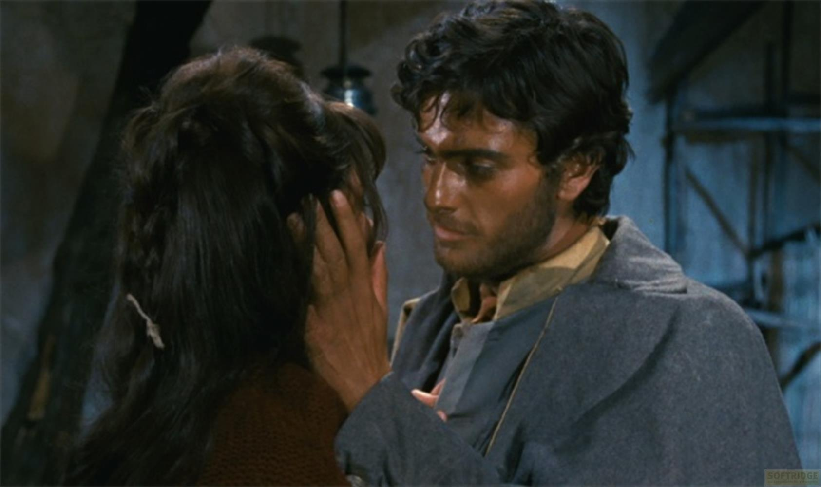 Uomo dai capelli scuri tocca il viso di donna dai capelli scuri.