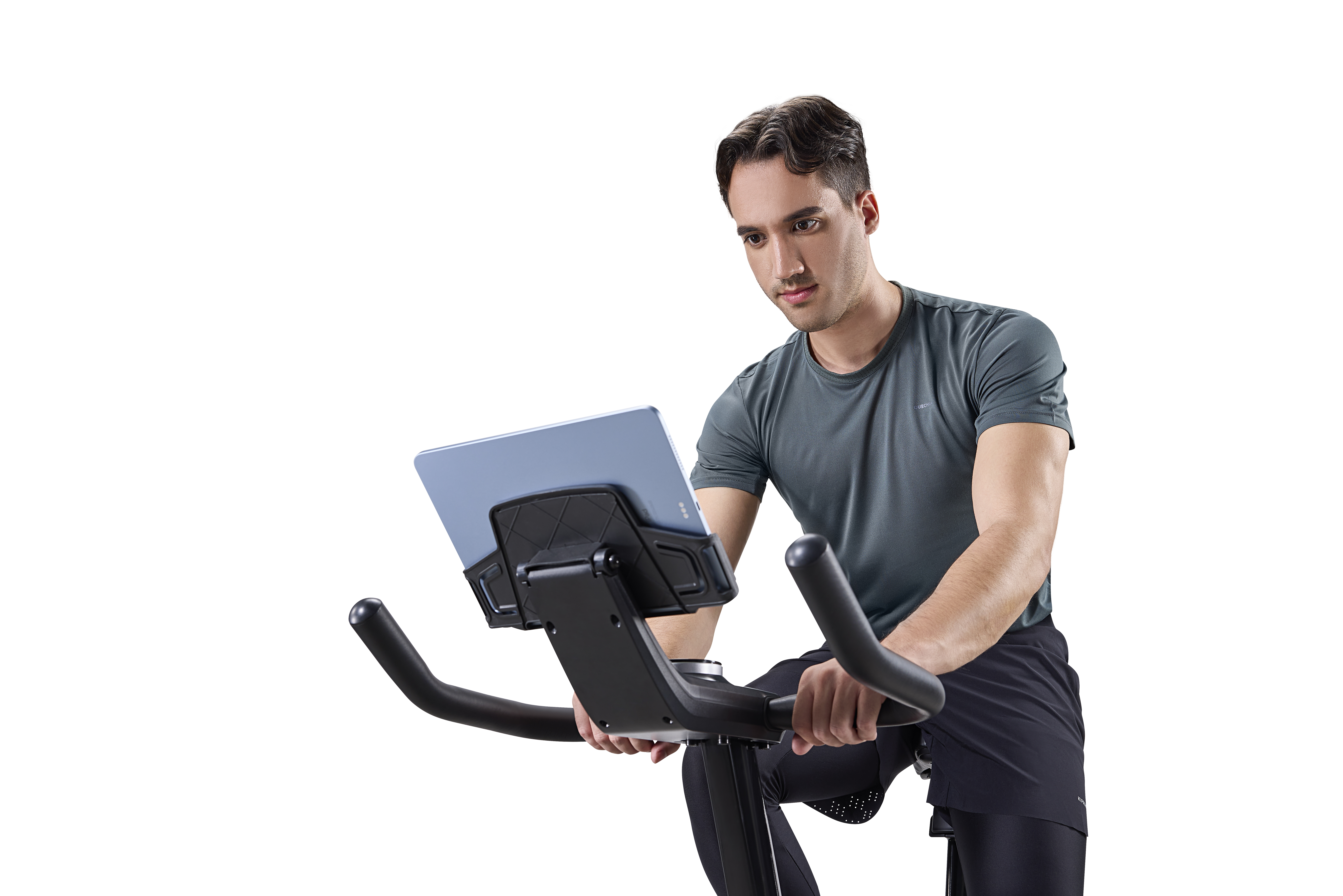 Un hombre en una bicicleta estática mirando una tablet.