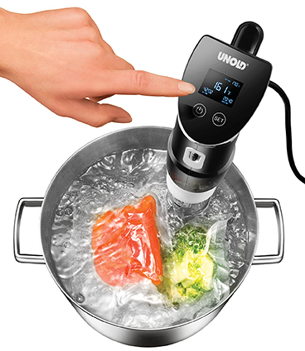 Ein Sous-vide-Gerät gart Fisch und Brokkoli in einem Topf mit Wasser.