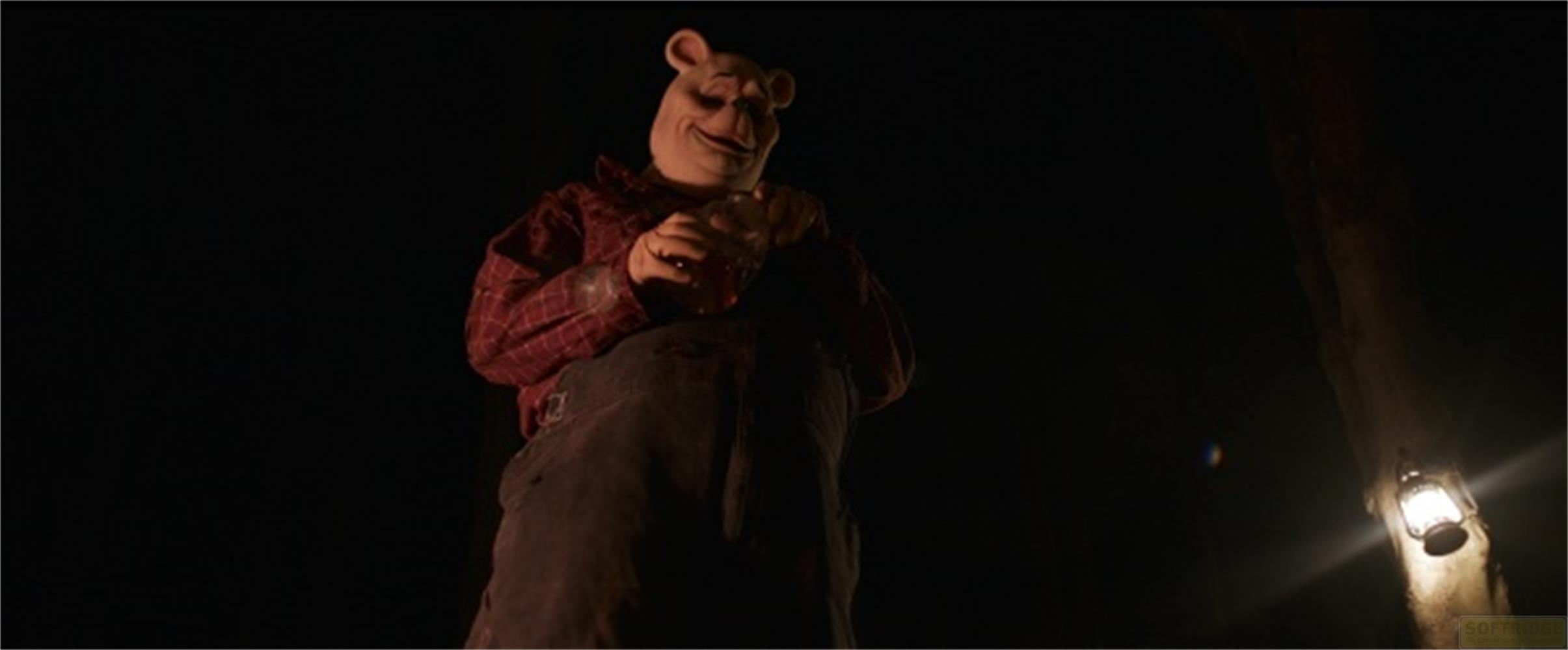 Una inquietante figura di Winnie the Pooh tiene un barattolo di miele in una foresta buia.