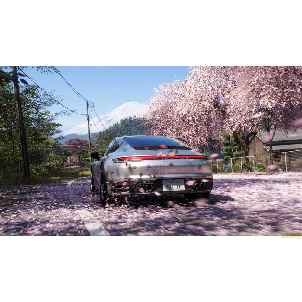 Silberner Porsche fährt auf einer Straße mit Kirschblüten und Schneebergen.