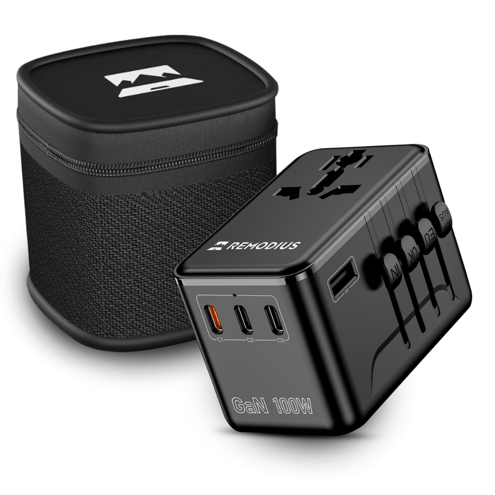Zwarte reisadapter met USB-poorten en opbergkoffer.